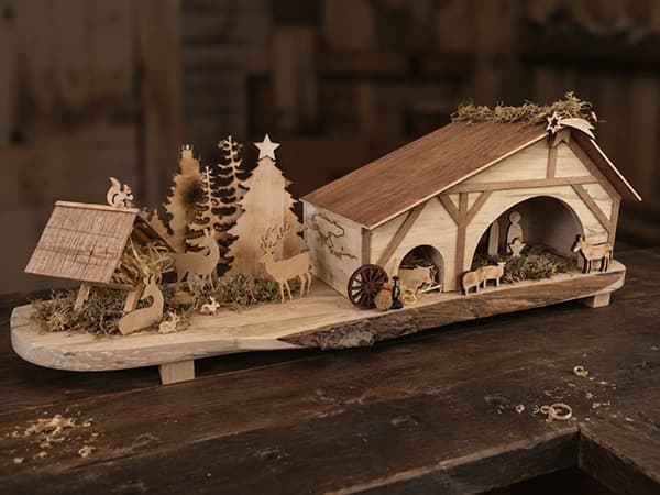 Längliche Krippenlandschaft aus Holz mit Stall, Wald, Tieren und Moos
