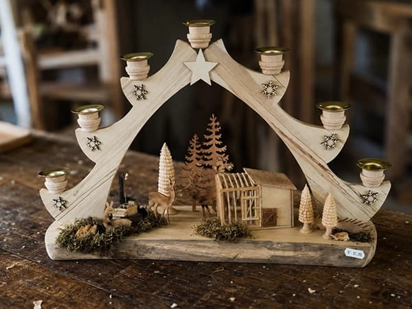 Adventsbogen aus hellem Holz mit Stern, Kerzenhaltern, Winterlandschaft und kleinen Tieren