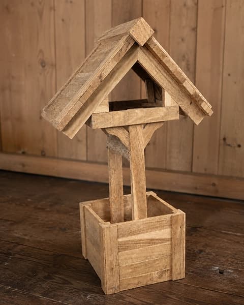 Handgefertigter Holzbrunnen mit Dach und viereckigem Pflanzkasten auf Holzboden
