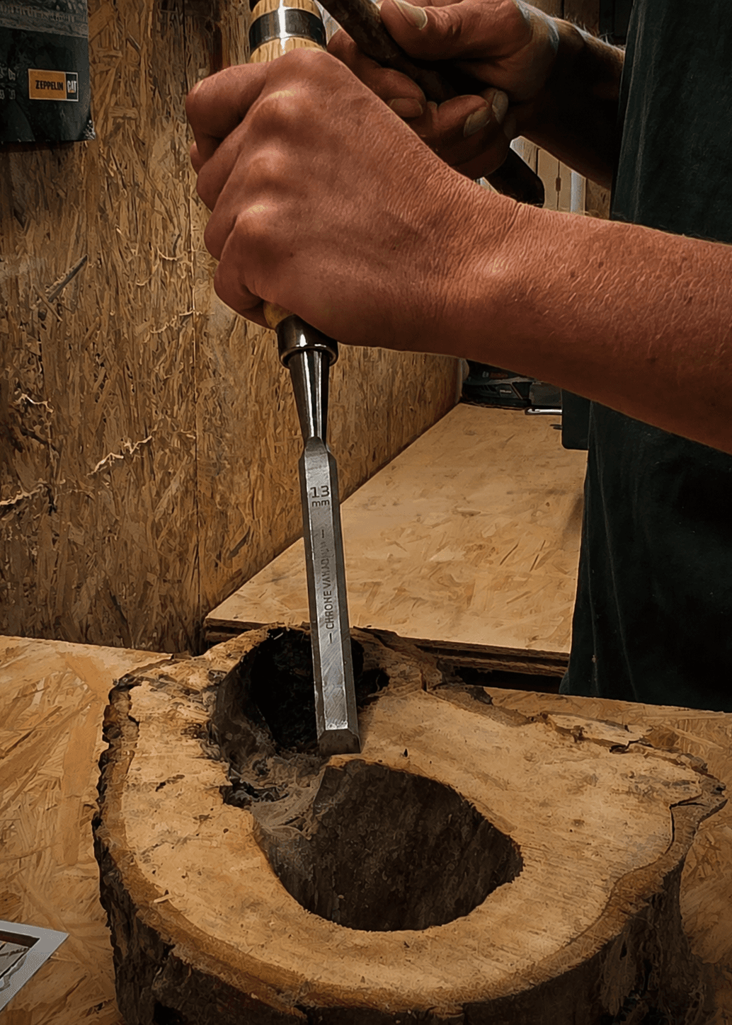 Hände, die mit einem Stechbeitel eine natürliche Holzform bearbeiten